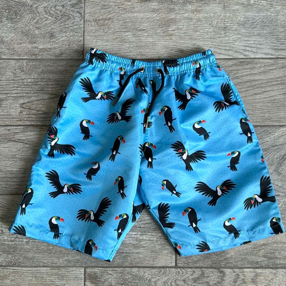 Juniors XL swim trunks, light blue color featuring a toucan pattern